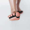 Pie usando separador dedos negro para corrección postural y estilo barefoot.